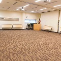 empty meeting room chairs and tables pushed to walls