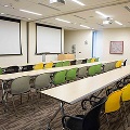 classroom setting with chairs, tables in a row facing two projection screens
