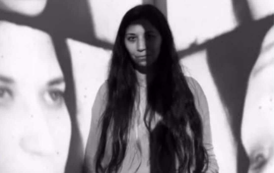 News image Black-and-white portrait of a woman with long hair, her face overlaid by abstract shadows.