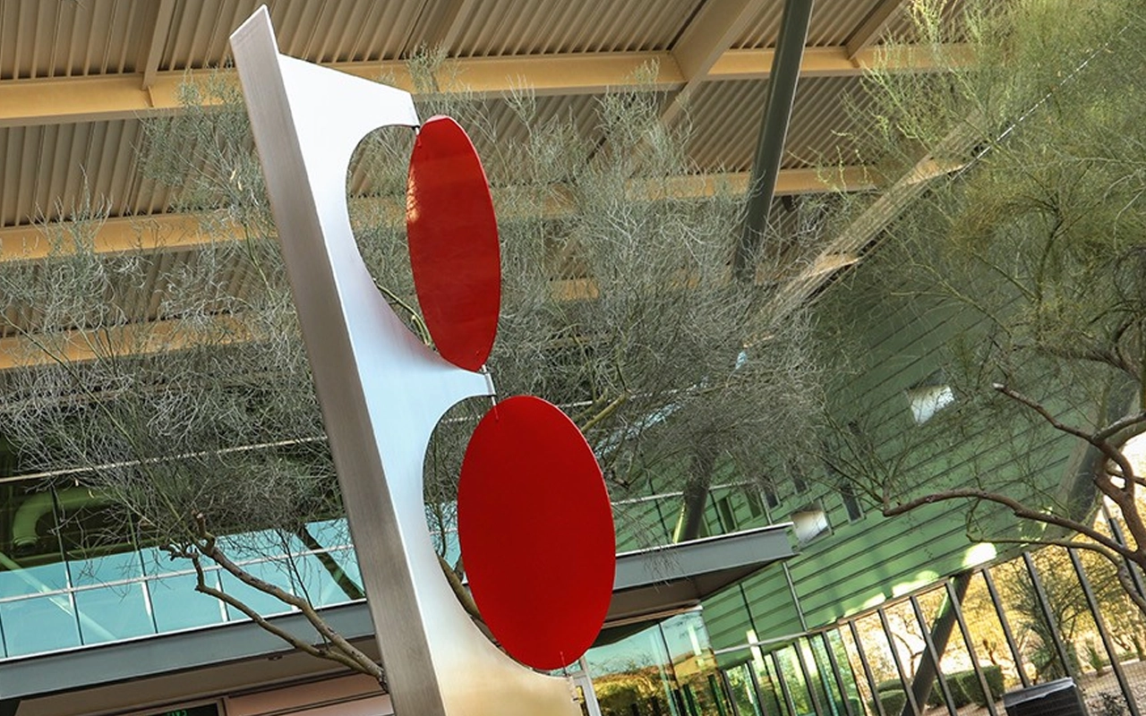 large metal sculpture with red dots
