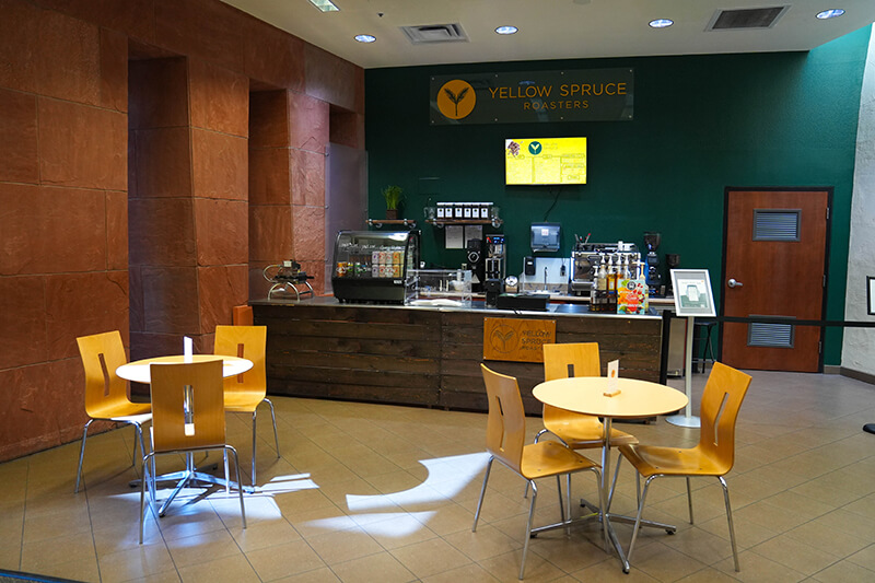 Yellow Spruce Roasters Cafe View view of cafe with 2 tables each with 3 chairs and order counter
